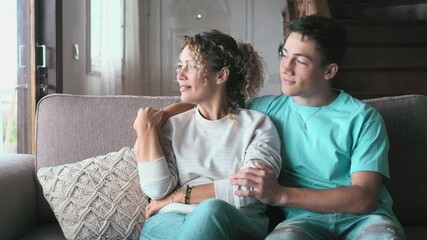 Happy middle age mother spend time with teenager son, relatives people hugging at home, adult attentive millennial grateful child wrapped in a plaid or warm sweater loving mommy caring 