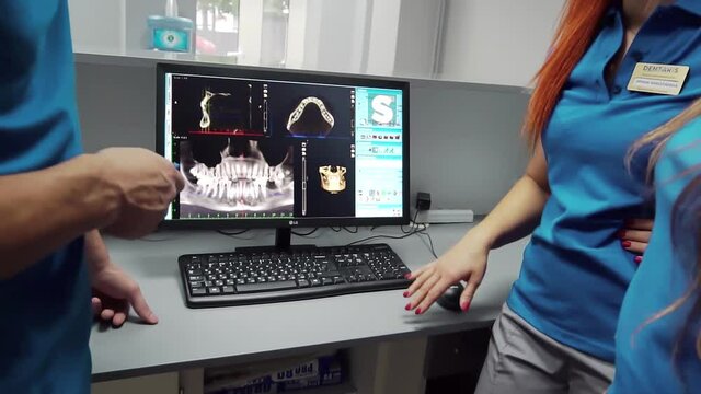 Dentists are discussing dental problems at report x-ray image on laptop screen t