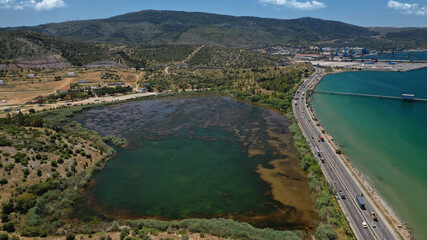 Fototapeta na wymiar Aerial drone photo of small lake of Koumoundourou in industrial area of Aspropirgos, Attica, Greece