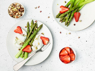 asparagus with cheese, nuts and strawberry on a plate