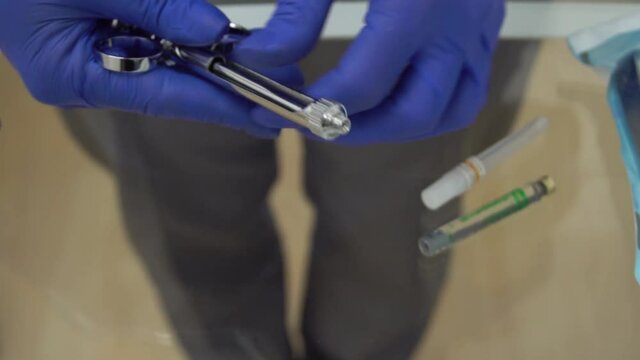 Slow Motion Medic hands in blue protective gloves with anaesthesia syringe. Dent