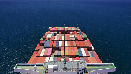 Aerial drone photo of Container ship carrying truck size colourful containers in deep blue Mediterranean sea