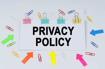 On the table there are paper clips and directional arrows, a sign that says - PRIVACY POLICY