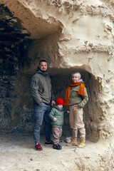 mother father and son child travel through the caves in warm clothes in the fall