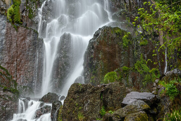 Waterfall in a mountain forest in early spring.