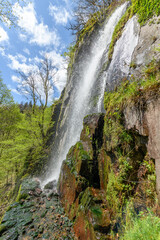 Obraz premium Waterfall in a mountain forest in early spring.