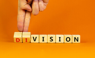 Division or vision symbol. Businessman turns wooden cubes and changes the word 'division' to 'vision'. Beautiful orange table, orange background. Business, division or vision concept. Copy space.
