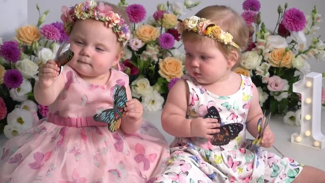 One-year-old twins on the birthday. Sisters celebrating their 1th birthday. 