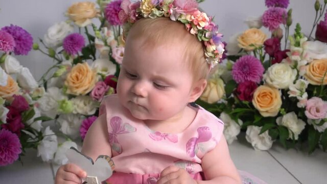 Slow Motion Sweet baby girl in a wreath of flowers