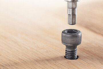 hex bolt screw hex bit  in wooden oaks plate. Spanner, bolt, screw and nuts.