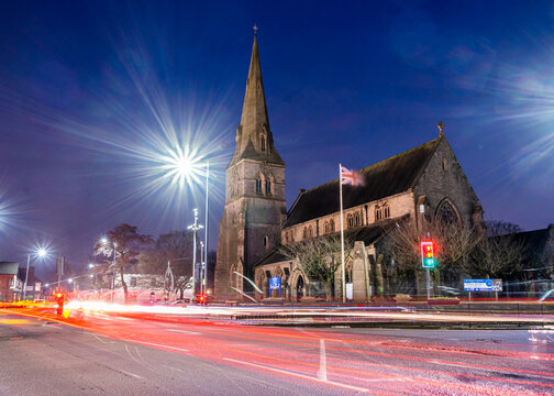 Wigan, UK, Feb 13 2021: A long exposure photograph documenting St Peter's Church, Hindley, during rush hour