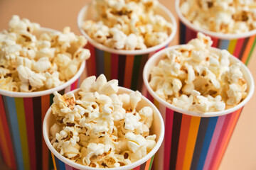 Popcorn in striped buckets on beige background