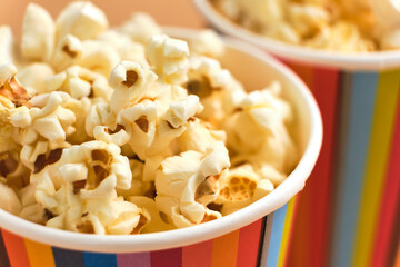 Popcorn in striped buckets on beige background