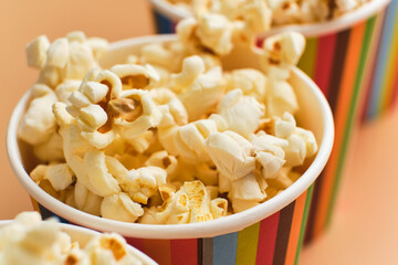 Popcorn in striped buckets on beige background