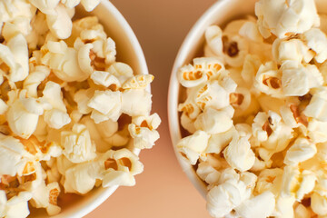 Popcorn in striped buckets on beige background