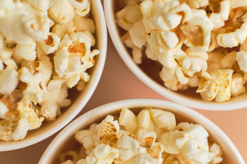 Popcorn in striped buckets on beige background