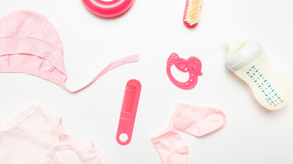 Obraz premium Clothes and accessories for newborn. Shirt, socks, toy, bottle, teether, comb. babies feeding with breast milk or infant formula powdered baby milk and toys.