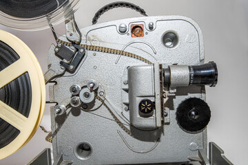 Old vintage film projector for watching films on film strip on a white background.