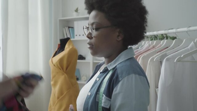 Stressed tailor listening to angry client, difficult customer in fashion studio