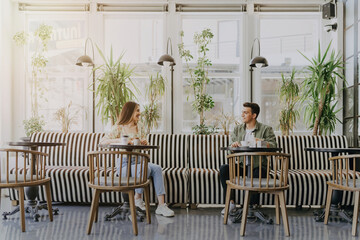 Fototapeta premium Young couple using disinfectant at coffee shop