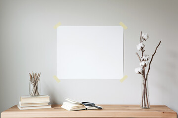 Horizontal poster mockup taped to a neutral coloured wall. Minimalist modern farmhouse props.