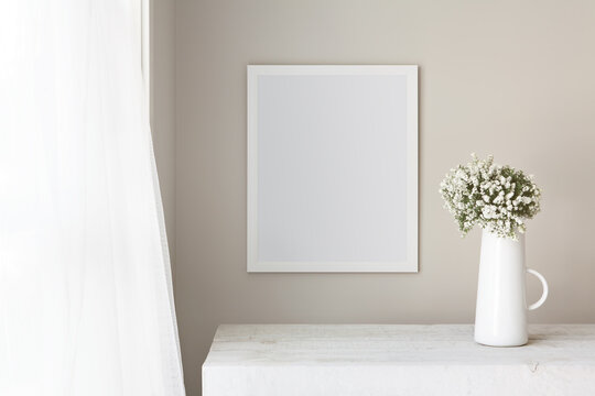 16x20 thin white vertical frame mockup template, hanging on a neutral coloured wall, next to an open window on a summers day. Fresh flowers in a white farmhouse jug.