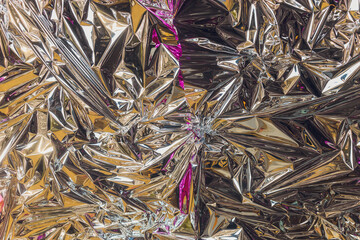 Silver foil background with shiny crumpled surface for texture background.