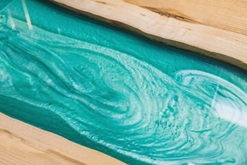 liquid turquoise epoxy on the kitchen table in the workshop