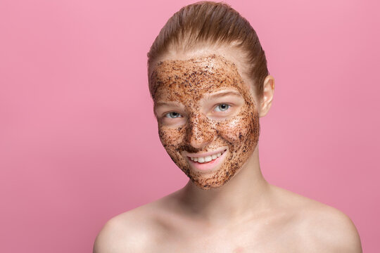 Facial Skin Scrub Coffee Grounds Mask On The Face Of A Beautiful Young Woman Organic Natural Cosmetology Pink Studio Background Isolate