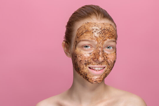 Facial Skin Scrub Coffee Grounds Mask On The Face Of A Beautiful Young Woman Organic Natural Cosmetology Pink Studio Background Isolate