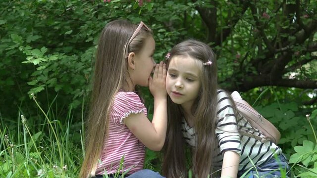 Slow Motion little girl is telling her secret to friend