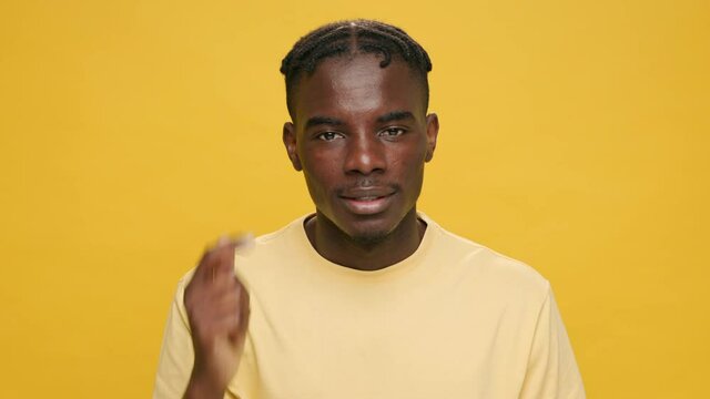 So what, What the hell? surprised black young African American man raising his hands up awaiting an excuse answer in yellow hat sunglasses on yellow background. People emotions concept. Lifestyle