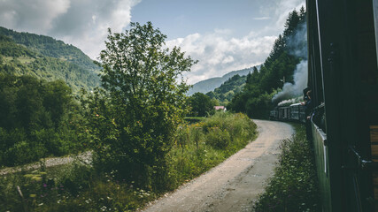 The romanian mocanita steem train going through the green mountains