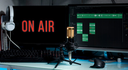 Mesa de trabajo de Blogger, con micrófono y computadora para transmisión de podcast en lineá,...