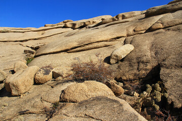 In the Bektau Ata tract, volcanic long flat layered rocks with stones lying on top, a small dry...