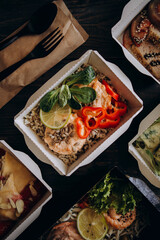 healthy food daily ration delivery concept. varied diet top view. food in paper disposable dishes. example of takeaway, food delivery and catering food.