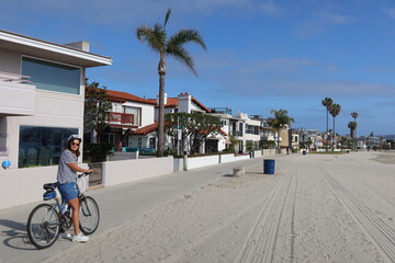 Woman Riding Her Bike on the Mission Bay Trail in California Next to Hotels and Residents on the Bay