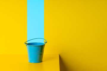 paint service concept. blue bucket over yellow background. design and decor conceptual - obrazy, fototapety, plakaty