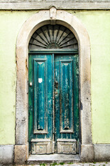 Fototapeta na wymiar Old and colorful green wooden door with iron details