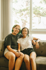 Obraz premium Novias lesbianas sonrien y se abrazan sentadas en el sofá de su sala 