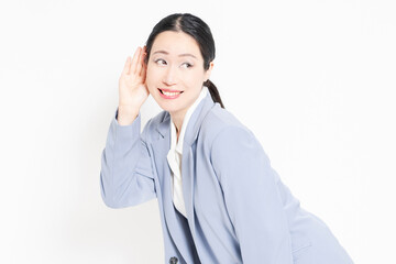 白バックの前に立って、聞き耳を立てる女性