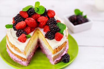 Delicious berry cake decorated with fresh raspberries and blackberries.