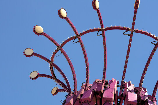 Gears and struts of an amusement park ride against a summer blue sky.