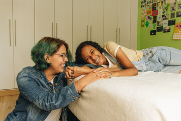 Pareja de jóvenes lesbianas peruanas riéndose juntas en su habitación 