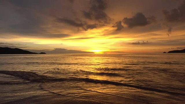 Dramatic sea sunset or sunrise Burning golden sky and shining golden waves Beautiful light reflection on sea surface Amazing landscape or seascape 4-K Nature footage