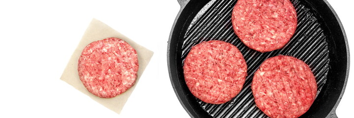 Raw Minced Steak Burgers in Grill Pan Isolated On White Background, Overhead View. Uncooked Beef Ground Meat Patties for Grilling. Burgers for BBQ Grill on Wood Board With Grill Tools, Top View.