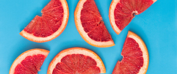 Pattern of red grapefruit slice on blue background. Fruit summer pattern.
