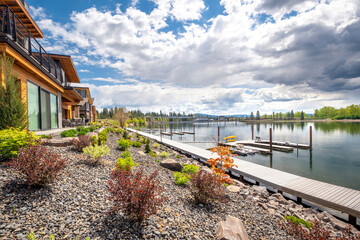 Million dollar waterfront homes along the Spokane River near lake Coeur d'Alene, in the mountain resort town of Coeur d'Alene, Idaho, USA. - obrazy, fototapety, plakaty