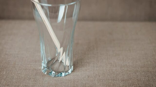 An eco straw. A view of an eco friendly drinking straw in the glass on the table.