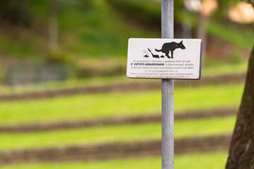 A sign about dog walking in Italy. Please clean up after your dog poop.